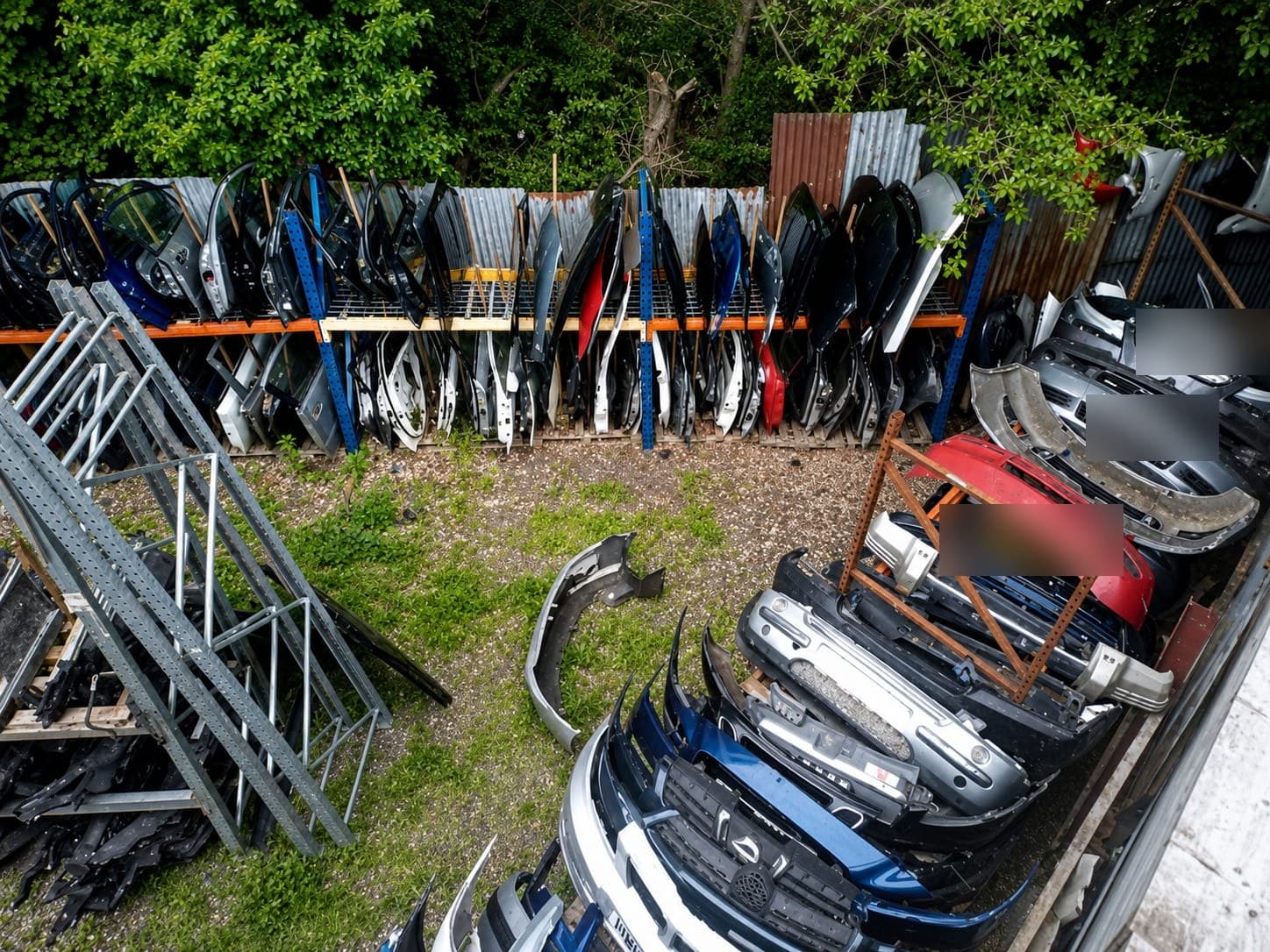 Racking stacked with doors, bumpers and body panels recovered from end-of-life vehicles